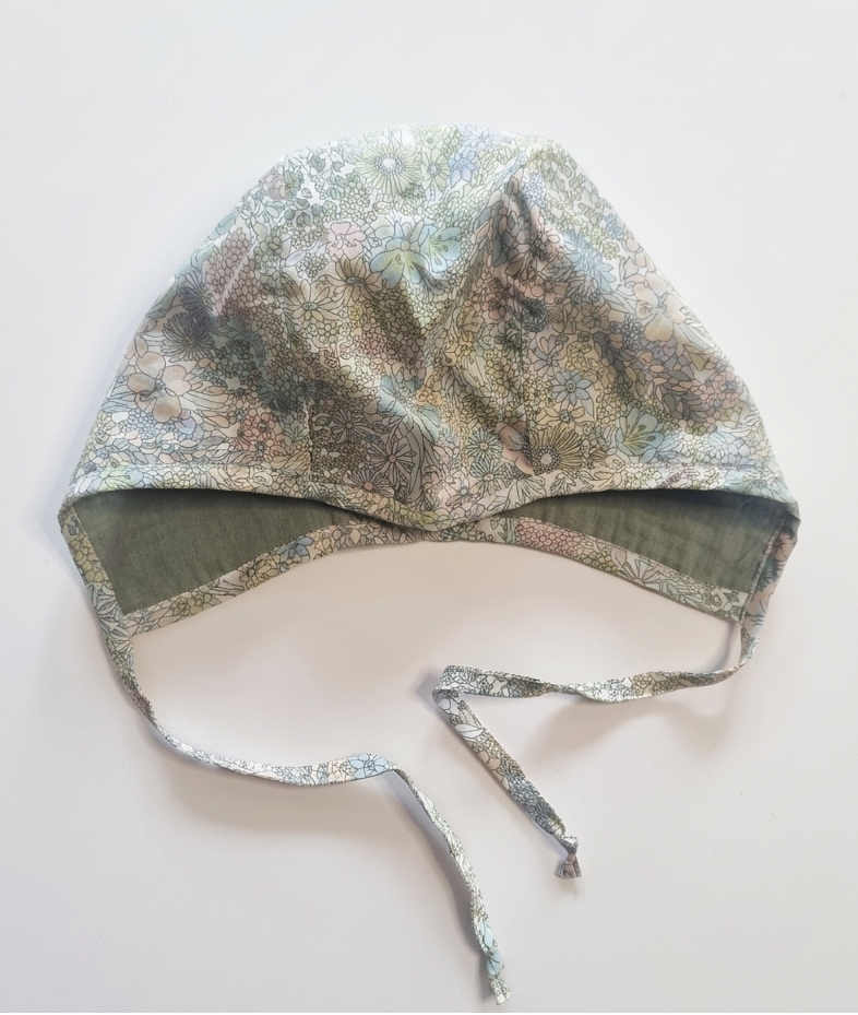 Floral patterned baby bonnet on a white background