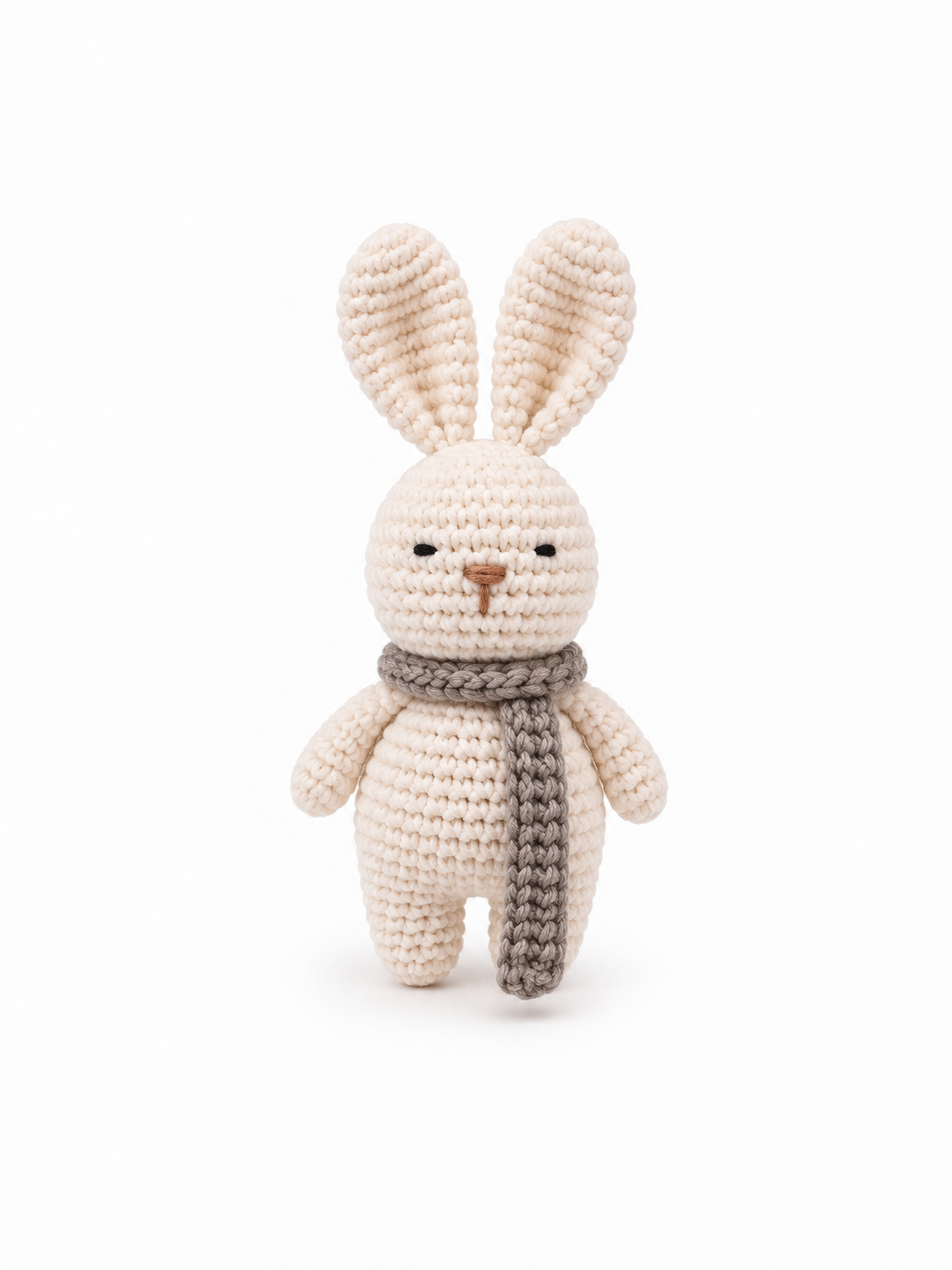 Handmade cream crochet bunny with a chunky gray scarf on a white background