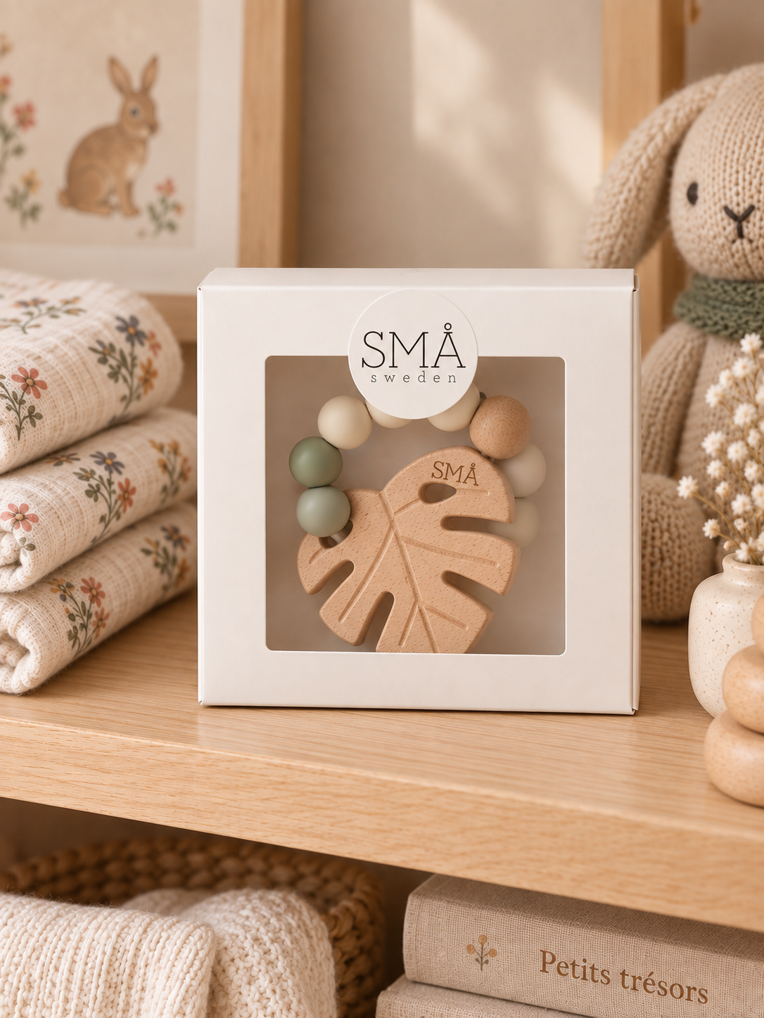 SMÅ Leaf Baby Teether in a square white gift box with window displayed on a wooden boutique shelf